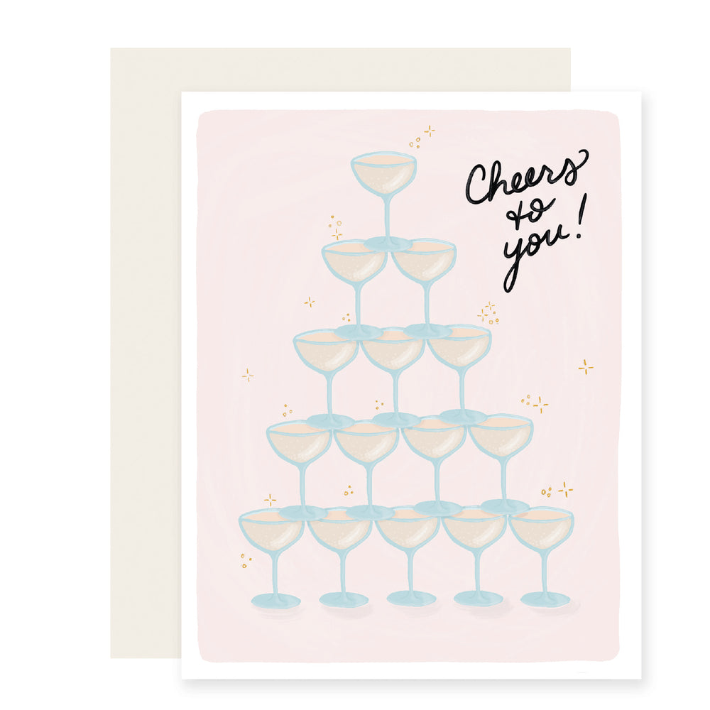 Congratulations card with a light pink background featuring an illustrated pyramid of champagne glasses. The card reads 'Cheers to You,' exuding celebratory vibes and extending best wishes.