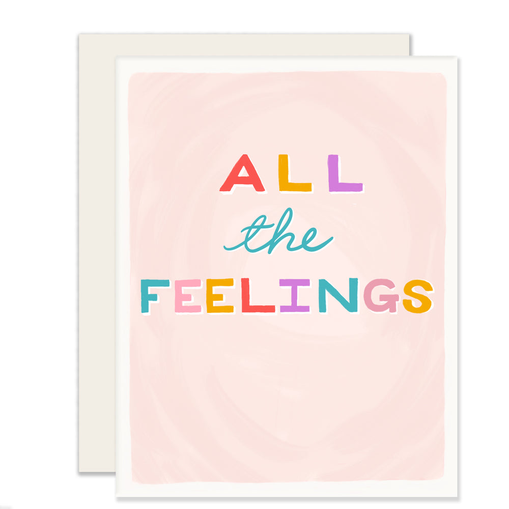 A versatile light pink greeting card featuring simple, colorful block letters that read 'All the Feelings,' expressing a wide range of emotions in a supportive, playful, and heartfelt  way. 