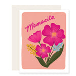 a vibrant Mother's Day card featuring bright pink and blue florals on the front. The top of the card is adorned with fun cursive writing that reads 'Mamacita.' The card is beautifully illustrated and exudes a lively and cheerful vibe.