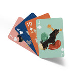 A deck of charmingly illustrated dog playing cards. Each card has vibrant dog illustrations, some of which are dressed in costumes. This delightful deck is perfect for dog lovers and card enthusiasts, offering a colorful and whimsical experience. 