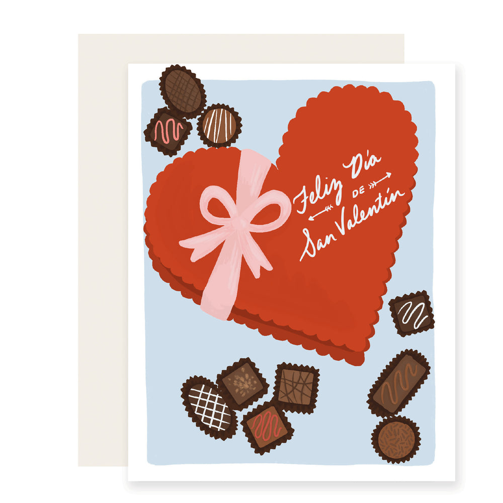 A beautifully illustrated Valentine's Day card in Spanish, adorned with an iconic heart-shaped box of chocolates. The card reads 'Feliz Día de San Valentín,' adding a touch of sweetness to the delightful illustration.